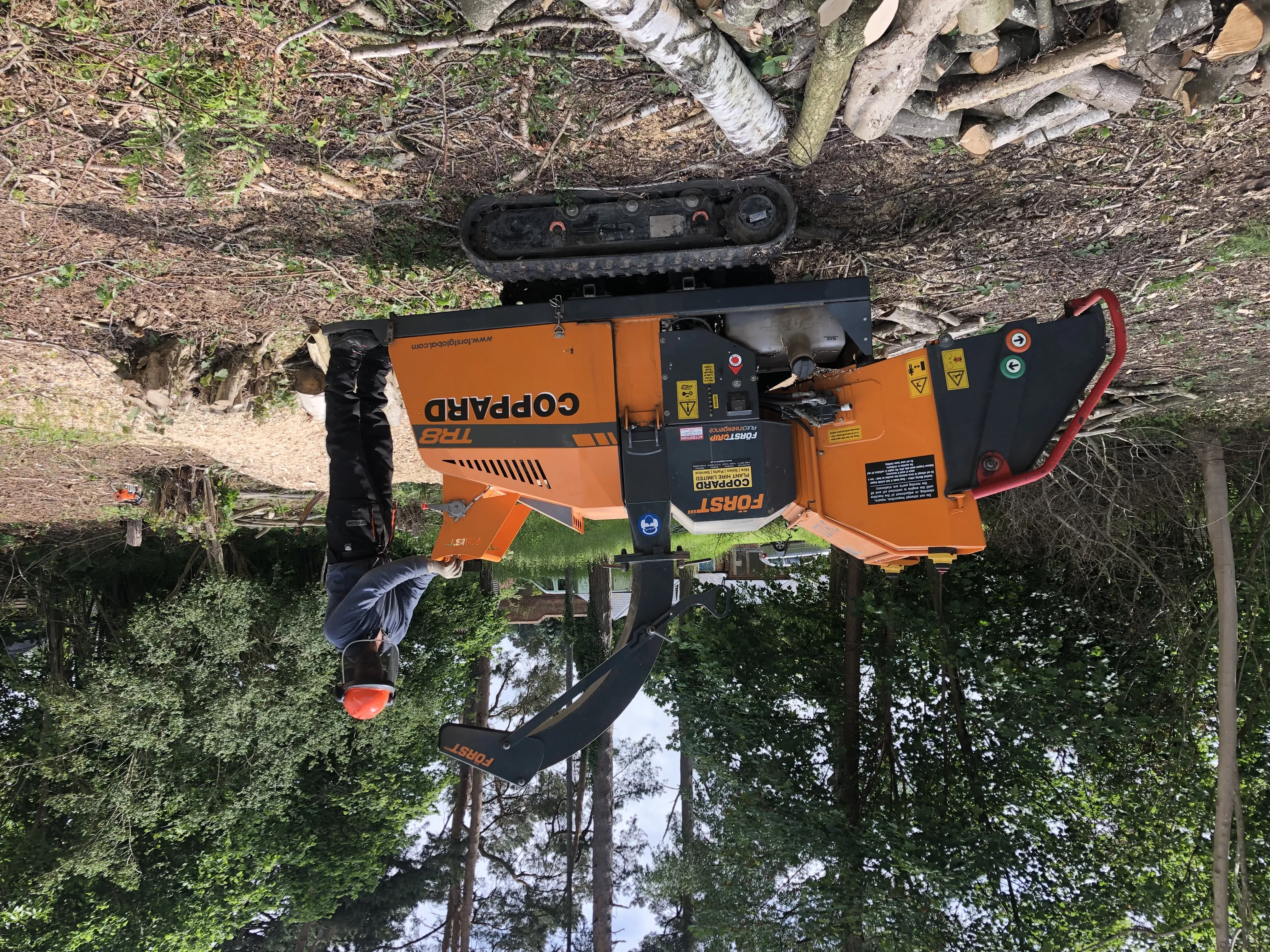 Tree surgeon operating a large tracked wood chipper