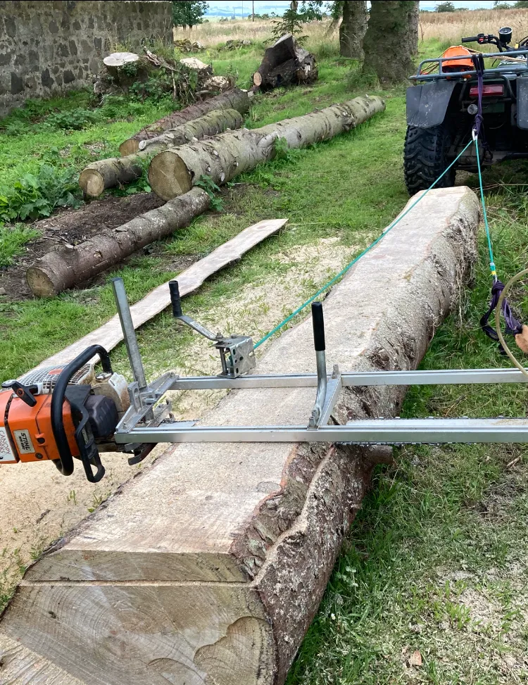 Chainsaw mill rig operating on a large log